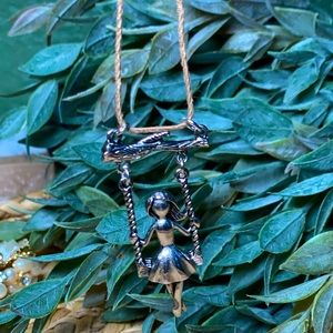 Girl swinging on tree necklace